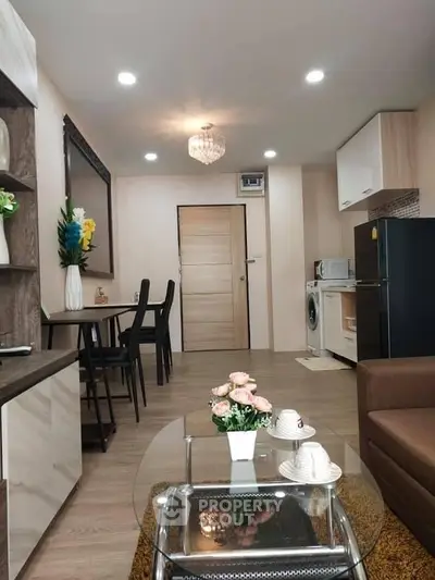 Modern living room with open kitchen, featuring stylish decor and appliances, perfect for cozy urban living.