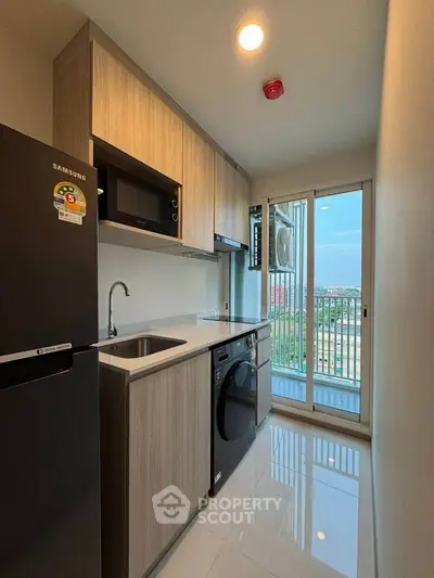 Modern kitchen with sleek appliances and balcony view in a stylish apartment.