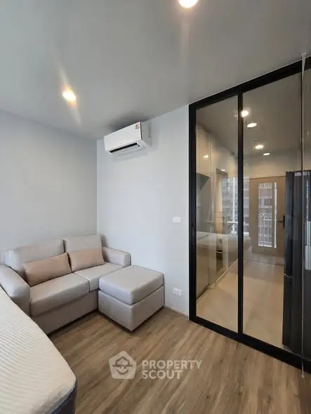 Modern living room with sleek glass partition and cozy sofa