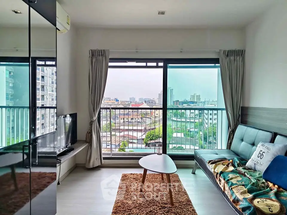 Modern living room with large windows offering stunning city views and cozy furnishings.