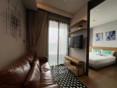 Modern living room with leather sofa and wall-mounted TV, adjacent to a cozy bedroom.