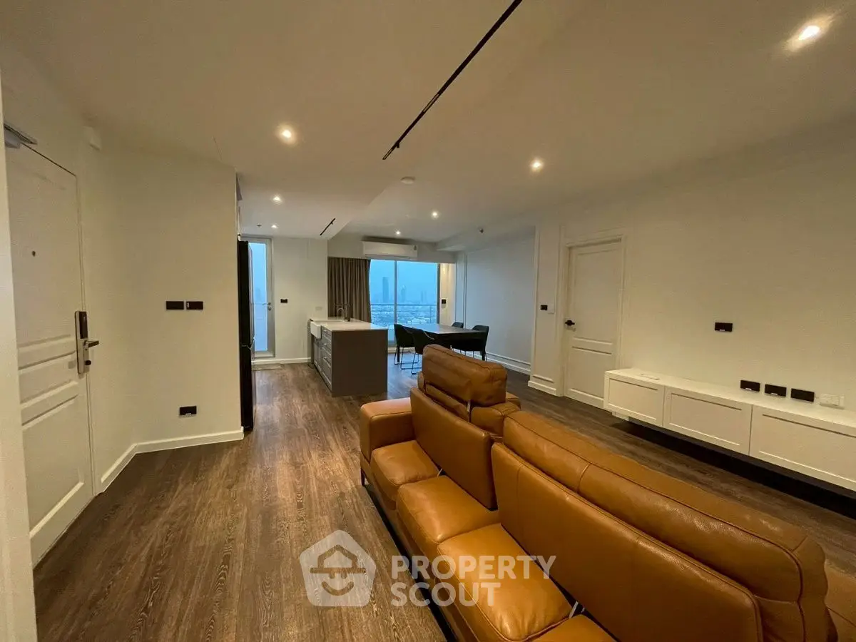 Modern living room with leather sofa and open kitchen layout