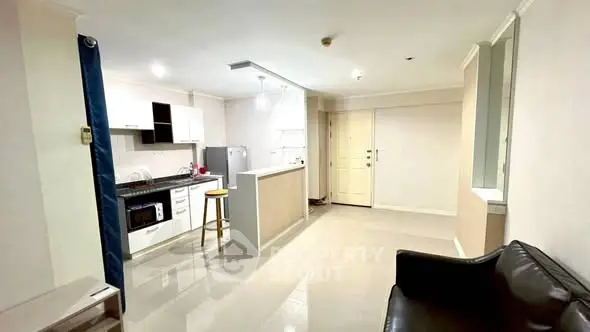 Modern open-layout kitchen and living area with sleek design and ample natural light.