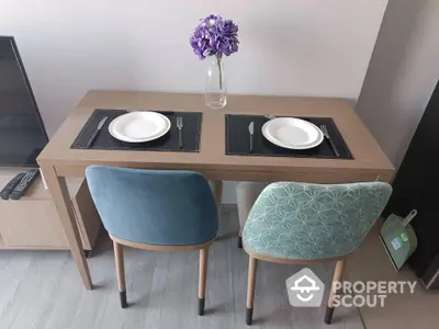 Modern dining area with stylish chairs and elegant table setting in cozy apartment.