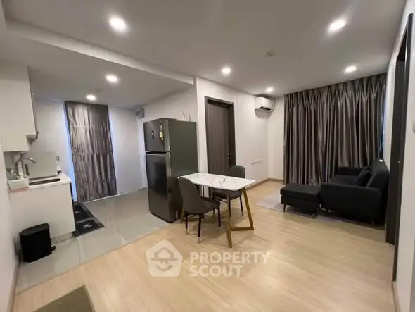 Modern open-layout living room with kitchen, dining area, and stylish furnishings.