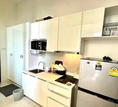 Modern kitchen with sleek white cabinets and stainless steel appliances in a compact layout.
