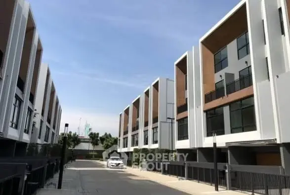 Modern townhouse complex with sleek architecture and spacious driveways.