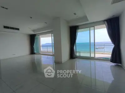 Spacious living room with ocean view and large windows in modern apartment