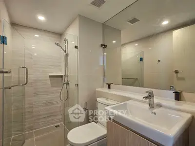 Modern bathroom with glass shower and sleek fixtures in a contemporary home.