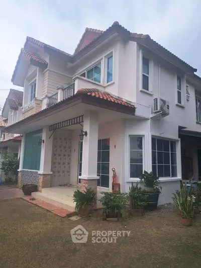 Charming two-story house with tiled roof and lush garden