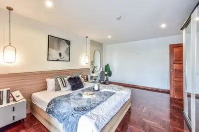 Spacious modern bedroom with stylish decor and wooden flooring