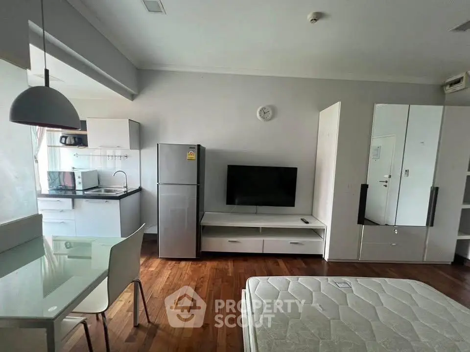 Modern studio apartment with sleek kitchen and hardwood floors