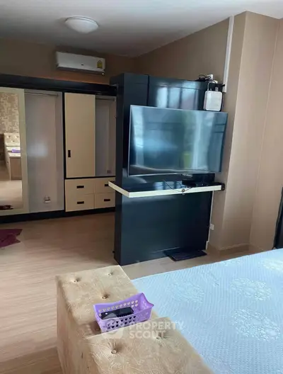 Modern bedroom with sleek TV setup and ample storage space