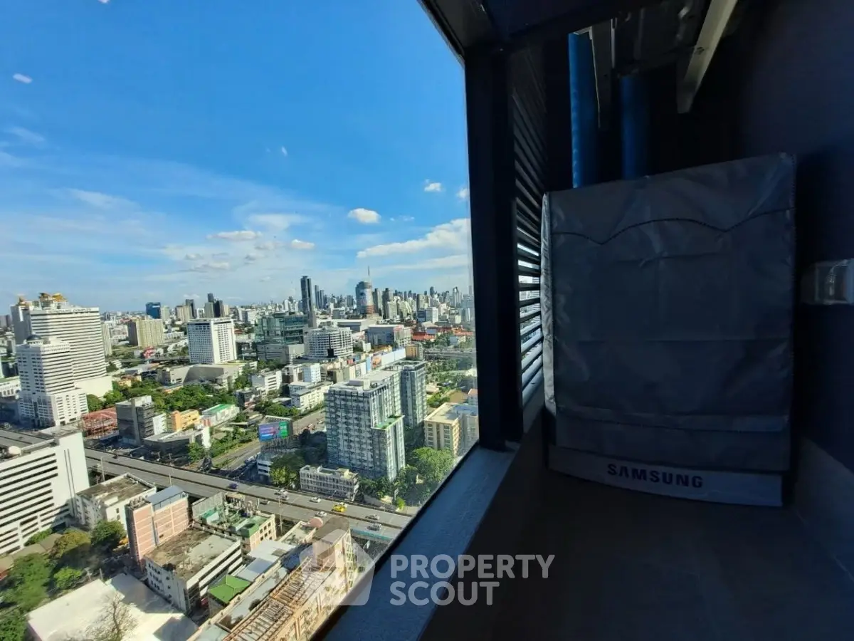 Stunning cityscape view from high-rise balcony with modern appliances.