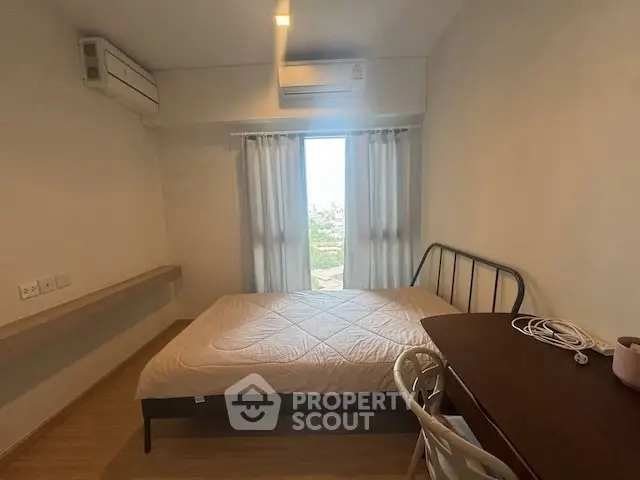 Cozy bedroom with natural light and modern furnishings, ideal for relaxation.