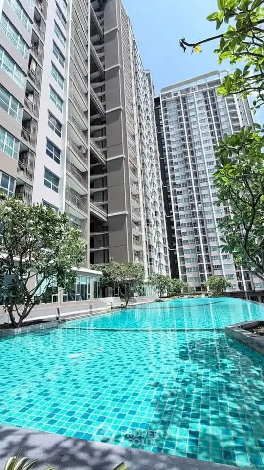 Luxurious high-rise apartment complex with stunning outdoor pool and modern architecture.