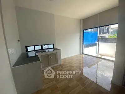 Modern kitchen with open layout and large windows in a bright, spacious apartment.
