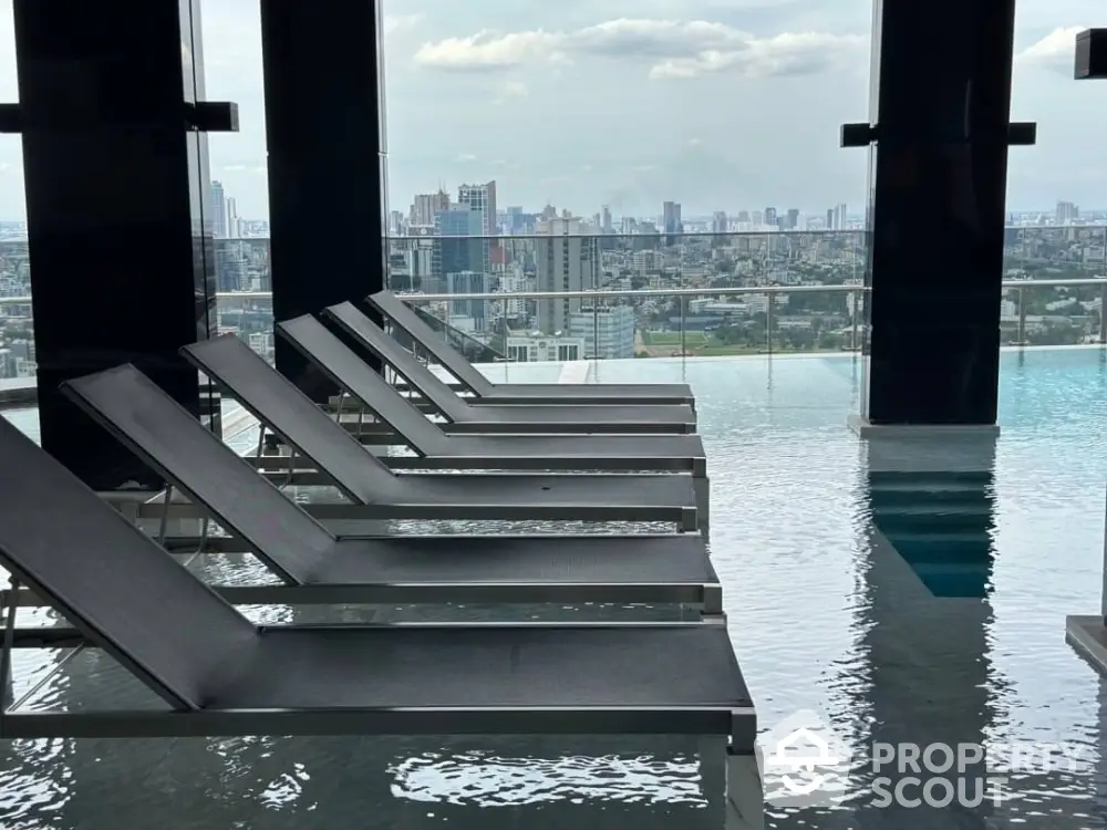 Luxurious rooftop pool with stunning city skyline view and modern lounge chairs.