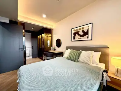 Modern bedroom with stylish decor and ensuite bathroom in a contemporary apartment.