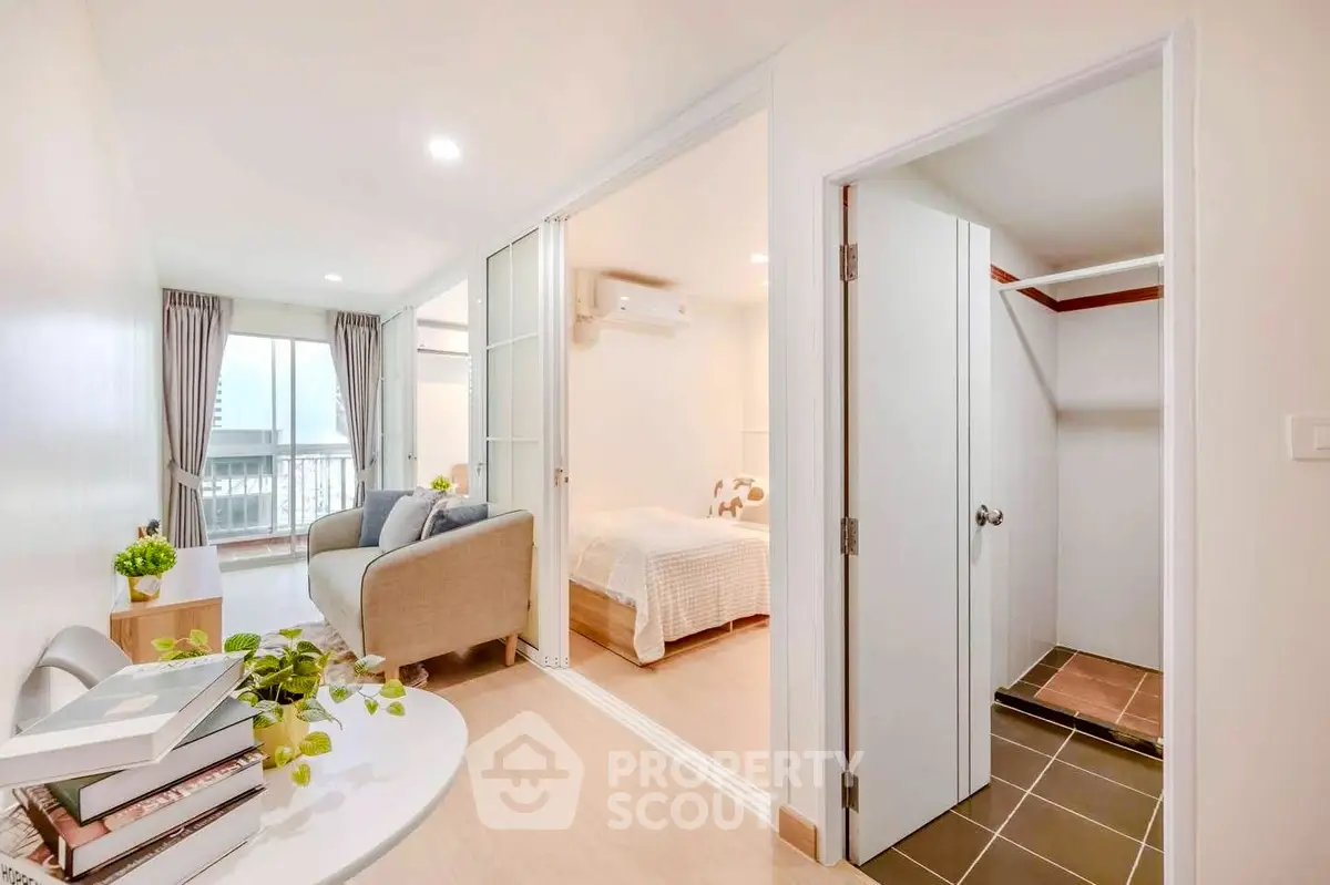 Modern apartment with cozy living room and bedroom, featuring sliding doors and bright decor.