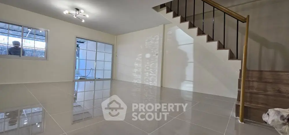 Spacious modern living room with sleek tile flooring and staircase