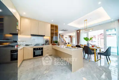 Spacious modern kitchen with open layout and dining area, featuring sleek appliances and elegant decor.