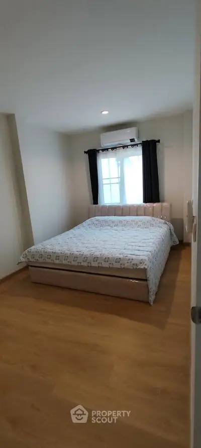 Cozy bedroom with wooden flooring and natural light