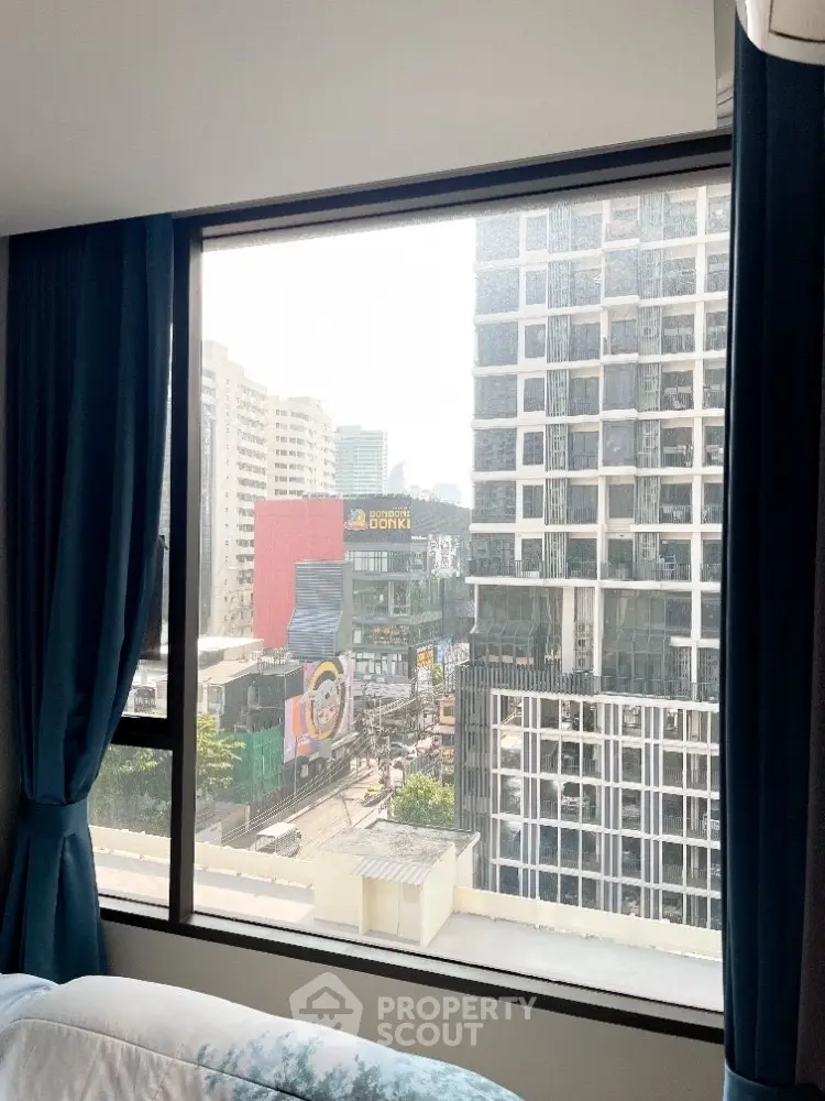 Stunning city view from high-rise apartment window with modern buildings.