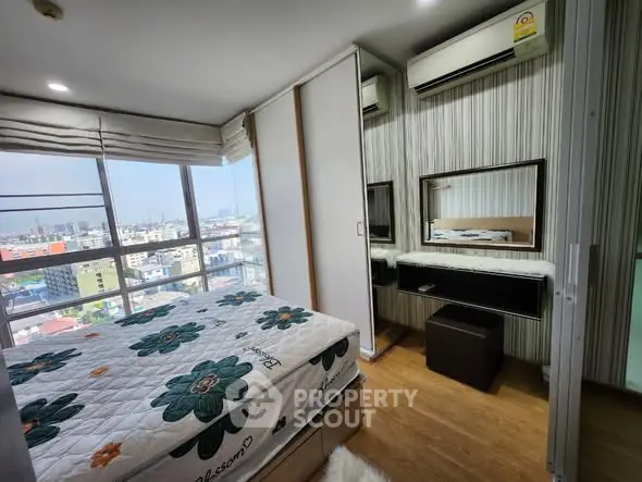 Modern bedroom with city view, stylish decor, and ample natural light.