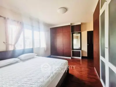 Spacious bedroom with large windows and ample closet space in a modern home.