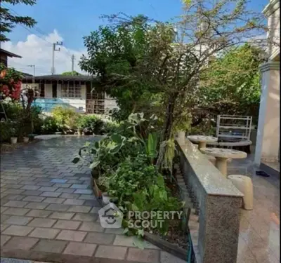 Charming garden view with lush greenery and outdoor seating area in a serene residential setting.