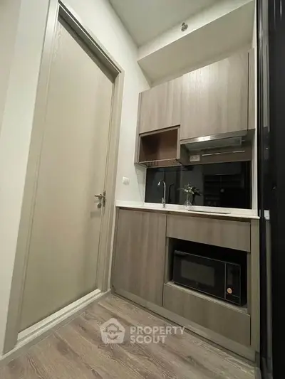 Modern compact kitchen with sleek cabinetry and built-in appliances