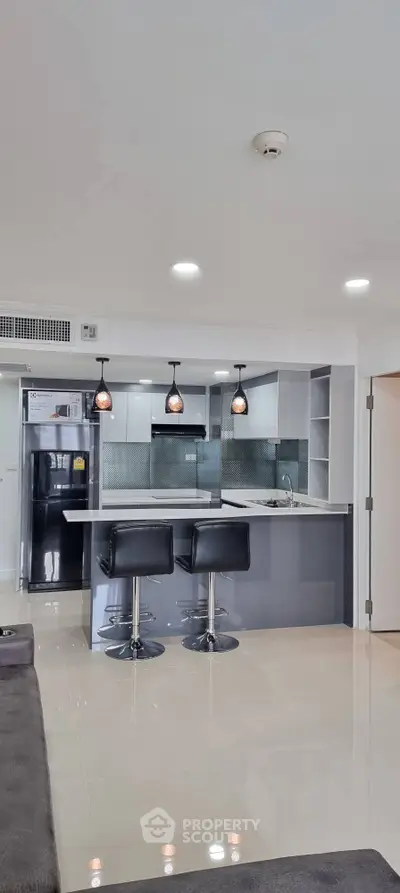 Modern kitchen with sleek design and stylish bar stools in open layout.