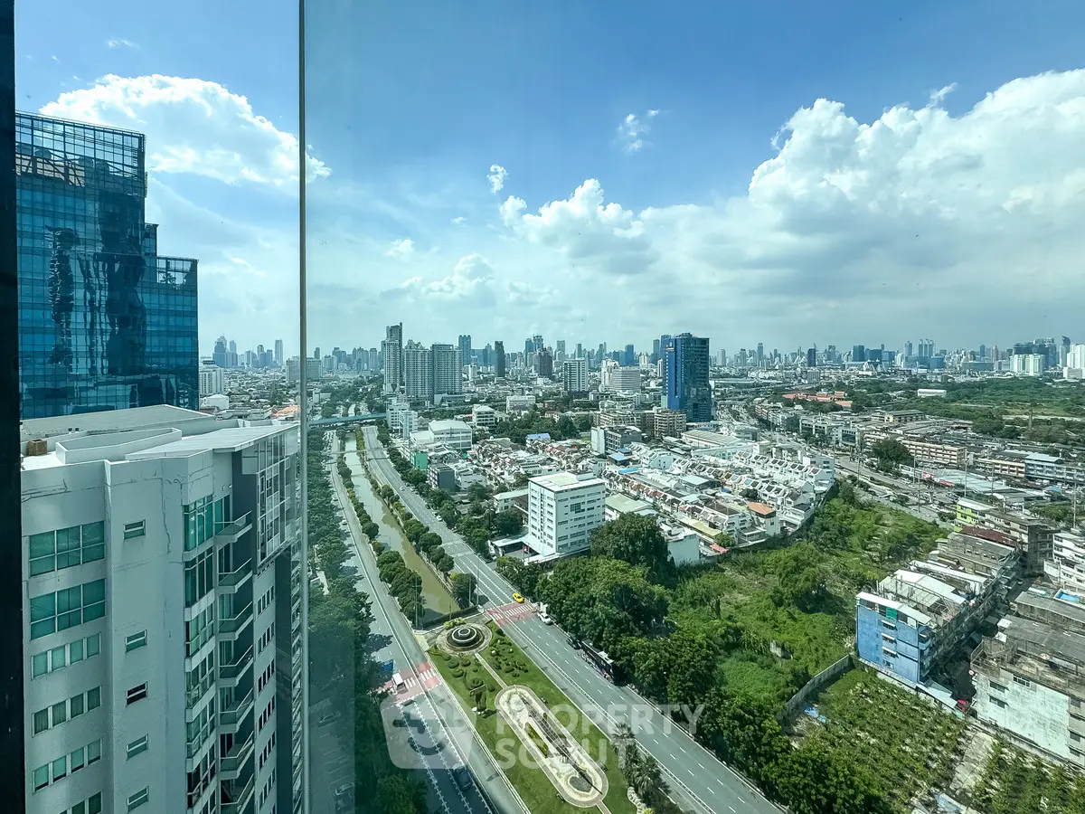 Stunning cityscape view from high-rise building with lush greenery and urban skyline.
