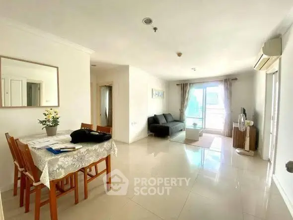 Spacious living room with dining area and natural light in modern apartment.