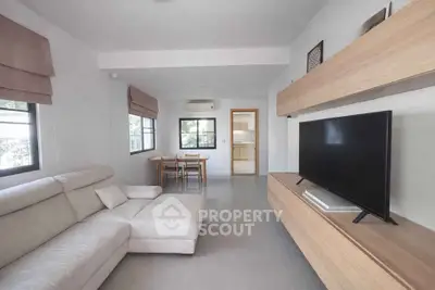 Modern living room with sleek furniture and large TV, open layout design