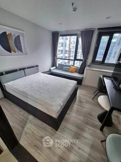 Modern bedroom with city view, featuring stylish decor and natural light.