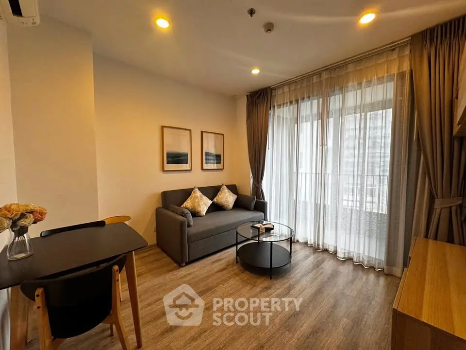 Modern living room with cozy sofa, stylish decor, and large windows for natural light.