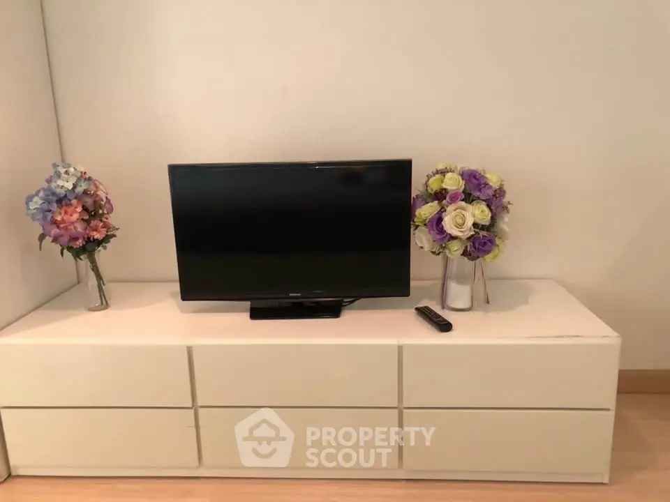 Modern living room setup with sleek TV stand and floral decor