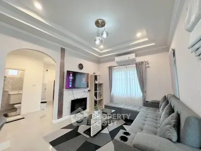 Modern living room with stylish decor, cozy seating, and elegant lighting in a contemporary home.