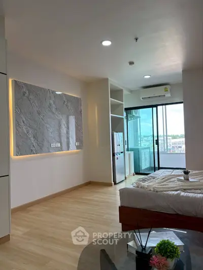 Modern bedroom with large window and city view, featuring stylish decor and natural light.