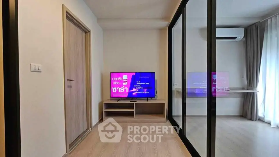 Modern living room with mirrored closet and wall-mounted TV in a stylish apartment.