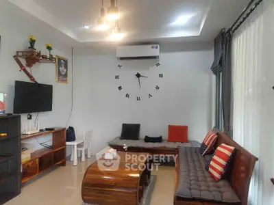 Stylish living room with modern decor, wall clock, and cozy seating area.