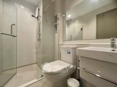 Modern bathroom with glass shower and sleek fixtures in a contemporary apartment.