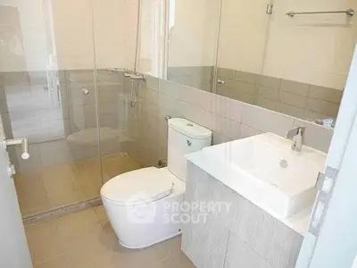 Modern bathroom with glass shower and sleek fixtures in a contemporary home.