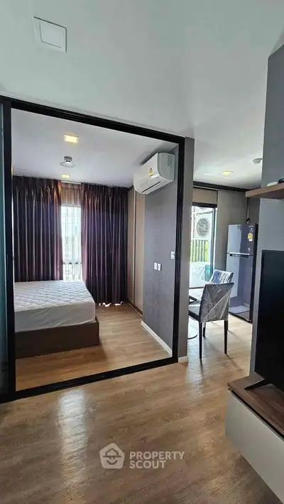 Modern apartment with open layout, featuring a cozy bedroom and dining area with natural light.