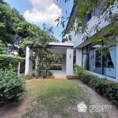 Modern house exterior with lush garden and large windows