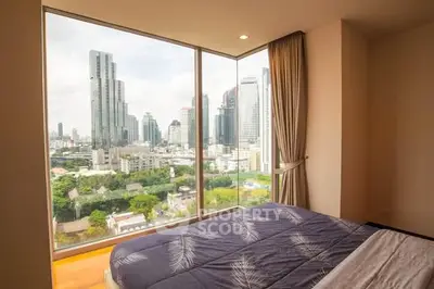 Stunning bedroom with panoramic city skyline view, featuring floor-to-ceiling windows and elegant decor.