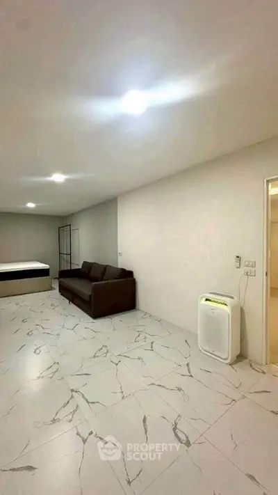 Spacious modern bedroom with marble flooring and cozy sofa