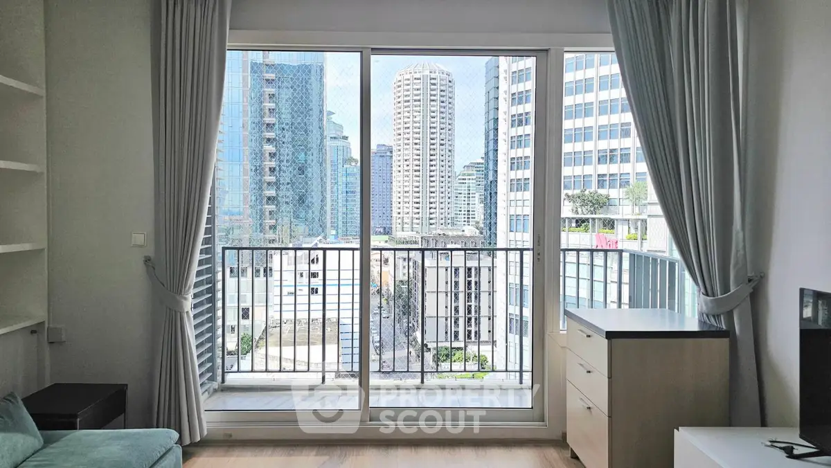 Modern living room with balcony view of city skyscrapers, featuring sleek furniture and floor-to-ceiling windows.